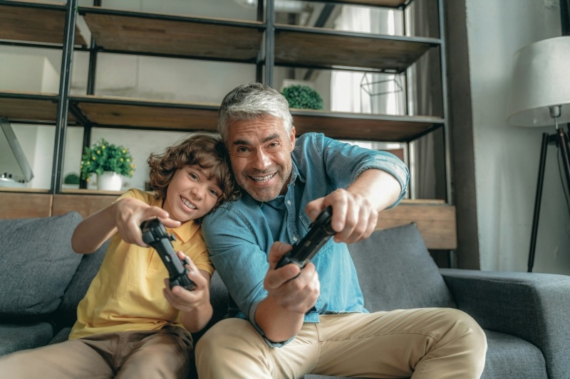 father and kid playing video game together